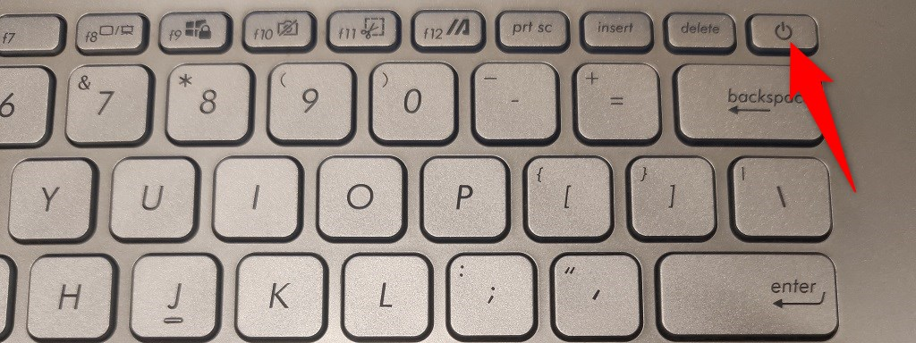 Power button highlighted on the keyboard of an Asus laptop.